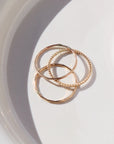 14k gold fill SoHo Ring Set placed on a white plate. This Ring set highlights each one of our go to stacking rings including the stacking ring, spiral ring, and sequins ring. These rings are made to live in made to wear everyday.