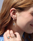 Model wearing a 14k gold fill back drop with a dainty curb chain, with three opal gemstones and one mini pearl set at the bottom