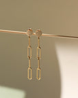 14k gold fill thick paper clip chain backdrops, displayed on a cream backdrop in the sunlight.