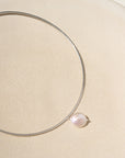 A sterling silver collarbone style necklace with a pearl dangling its center.