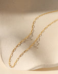 14k gold fill delicate cosette chain on wavy dish in the sunlight
