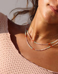 model wearing 14k gold fill cosette chain paired with beaded neckalces