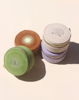 A collection of mini travel jewelry cases with embroidered sun designs, stacked together. They come in beige, green, brown, and purple colors.