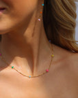 Model wearing a 14k Gold Fill necklace featuring six vibrant opals and a textured chain with bar, dot, and dash links.