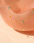 Disco Opal Necklace draping on a pink dish.