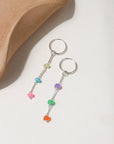 Disco Opal Earrings featuring six multicolored opals on a bar, dot, and dash chain design in sterling silver, dangling from a minimal hoop