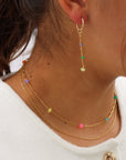 Model wearing a 14k Gold Fill necklace featuring six vibrant opals and a textured chain with bar, dot, and dash links.