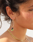 Model wearing a 14k gold fill drop earring with a chrysophrase gemstone wire wrapped at the bottom
