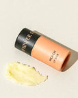 Flower Beauty peach lip balm on a beige background