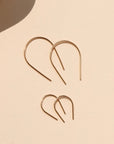 14k gold fill medium horseshoes and 14k gold fill small horseshoes laid in sunlight