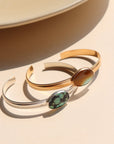 A sterling silver and 14k gold fill smooth cuff with a 13x18mm turquoise stone set at its center