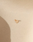 14k gold fill heart charm with jump ring on a light background in the sunlight