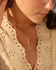 Model wearing Gold lariat necklace with circle pendant and double chain drop