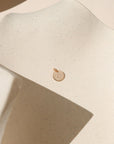 14k gold fill round disc with marathon miles hand stamped on it on a light dish