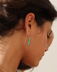 Model wearing 14k gold fill threaders with two turquoise tube shaped gemstones