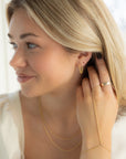 model wearing 14k gold fill chain stud earrings with 14k gold fill hand chain