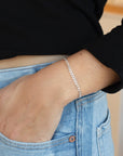 925 sterling silver cuban style chain link bracelet, worn by a model sporting a black sweater and blue jeans