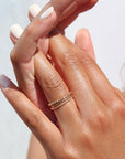 model wearing 14k gold fill sequin ring stacked with circle ring and spiral ring