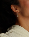 Gold hoop earrings featuring iridescent moonstone charms with soft, shimmering hues.