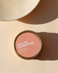 peach colored candle tin in the sunlight - scent is Palm Springs