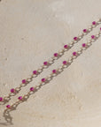 sterling silver chain bracelet with ruby gemstones on a light dish