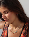 Model wearing Sedona Necklace with turquoise tube beads and red coral accents on a delicate gold filled chain.