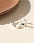 A small thick hammered sterling silver hoop displayed on a cream back drop.