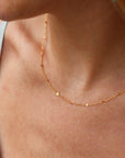 Model wearing 14k gold filled Sunspell Chain featuring delicate, light-reflecting links designed for layering or everyday wear.