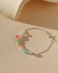 multicolored heart beads with sterling silver chain laid on light background in the sunlight