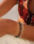 Model wearing Taos Bracelet featuring multicolored turquoise beads in soft blues, greens, and browns with a gold filled spring clasp.