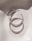 Token jewelry petite maeve hoops in sterling silver on a white dish