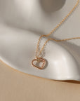 spiral wire heart shaped pendent in 14k gold fill on a simple 14k gold fill chain displayed on a wavy plate