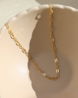 14k gold fill Sylvie choker laid on a tan plate in the sunlight.