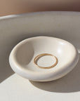 14k gold fill Minimal Ring Laid on a white ring dish. This ring features a simple band that is smooth, great for everyday wear.
