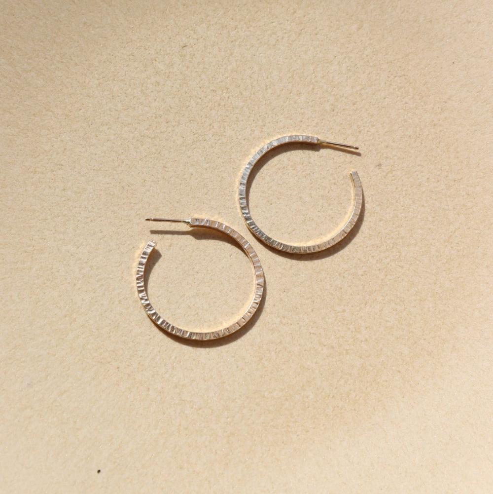 petite maeve hoops in 14k gold fill by token jewelry, a medium-sized hoop with a post, featuring a textured edge