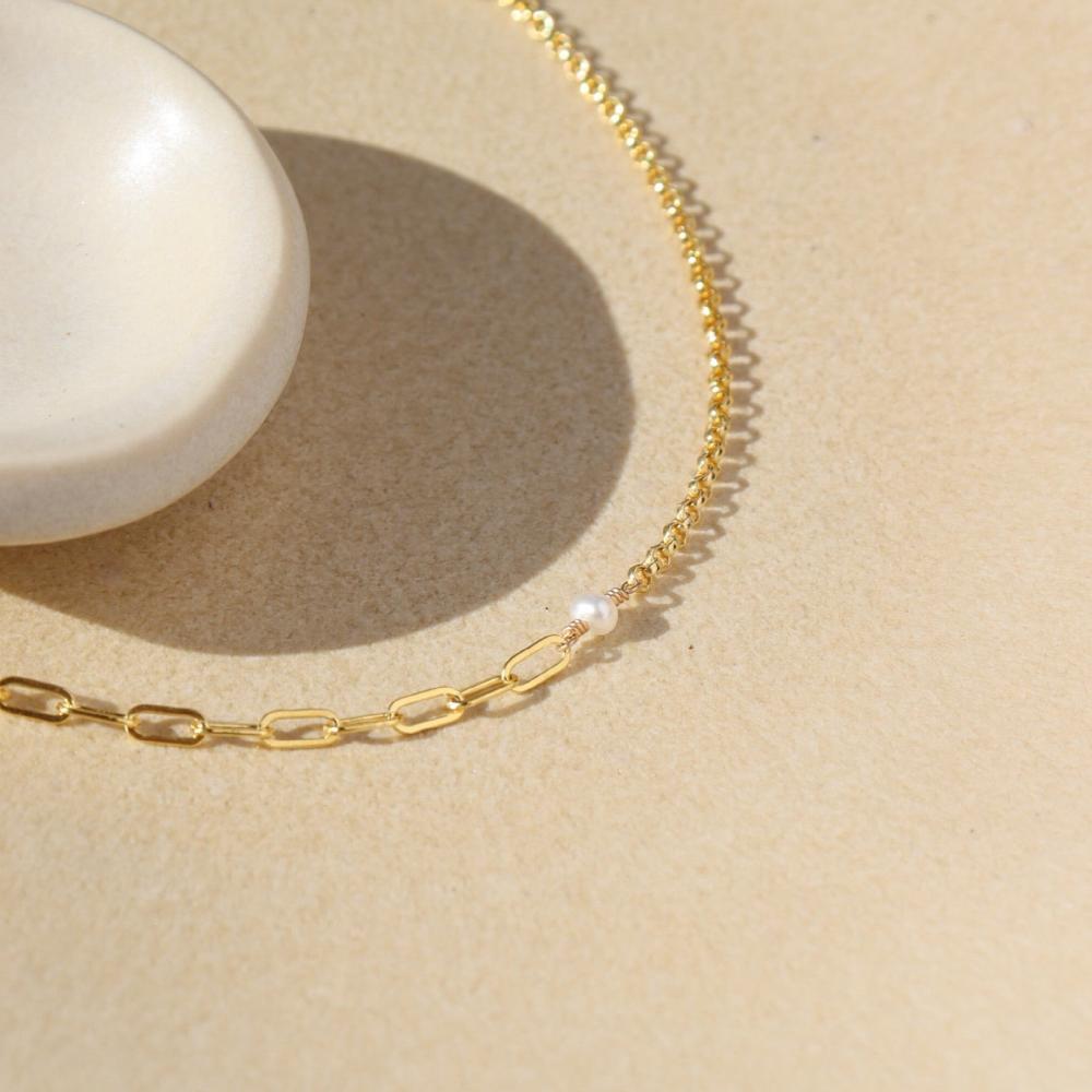 14k gold fill Emma bracelet laying on a tan plate in the sunlight.