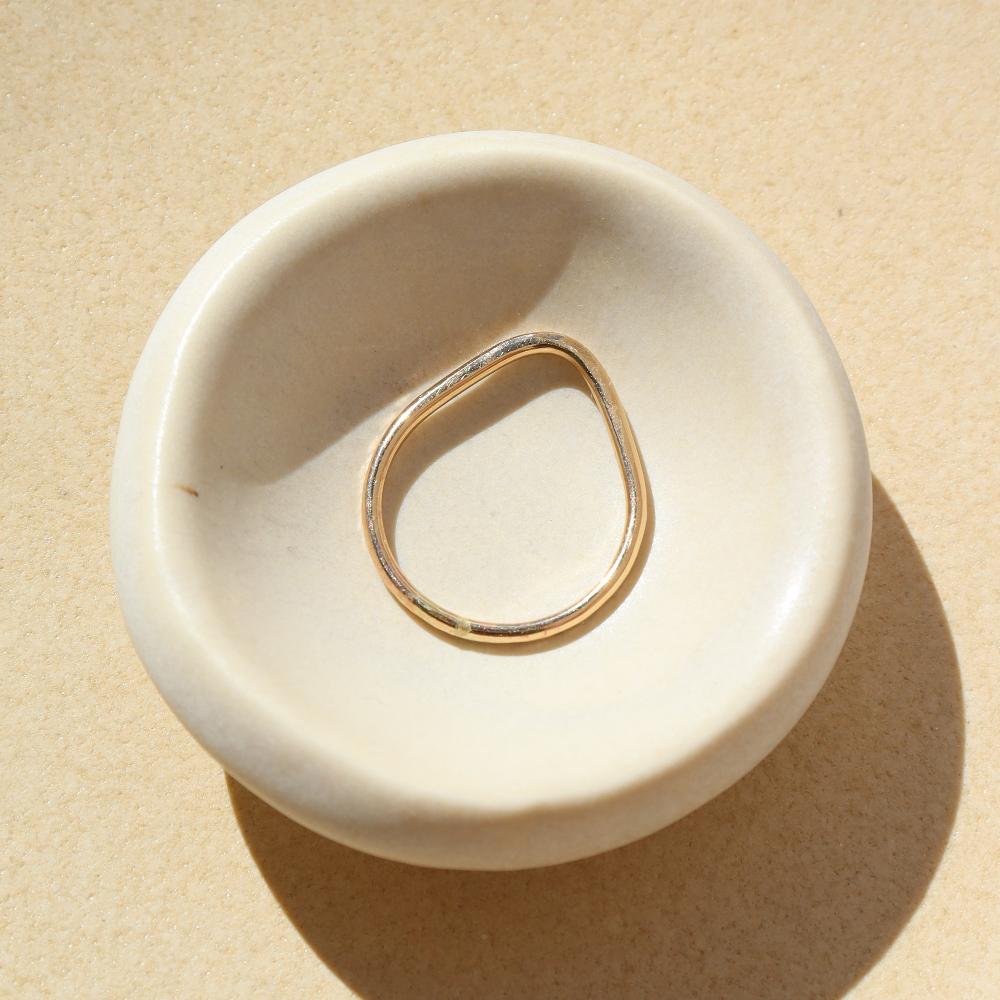 Summit Ring laid on a white plate in the sunlight