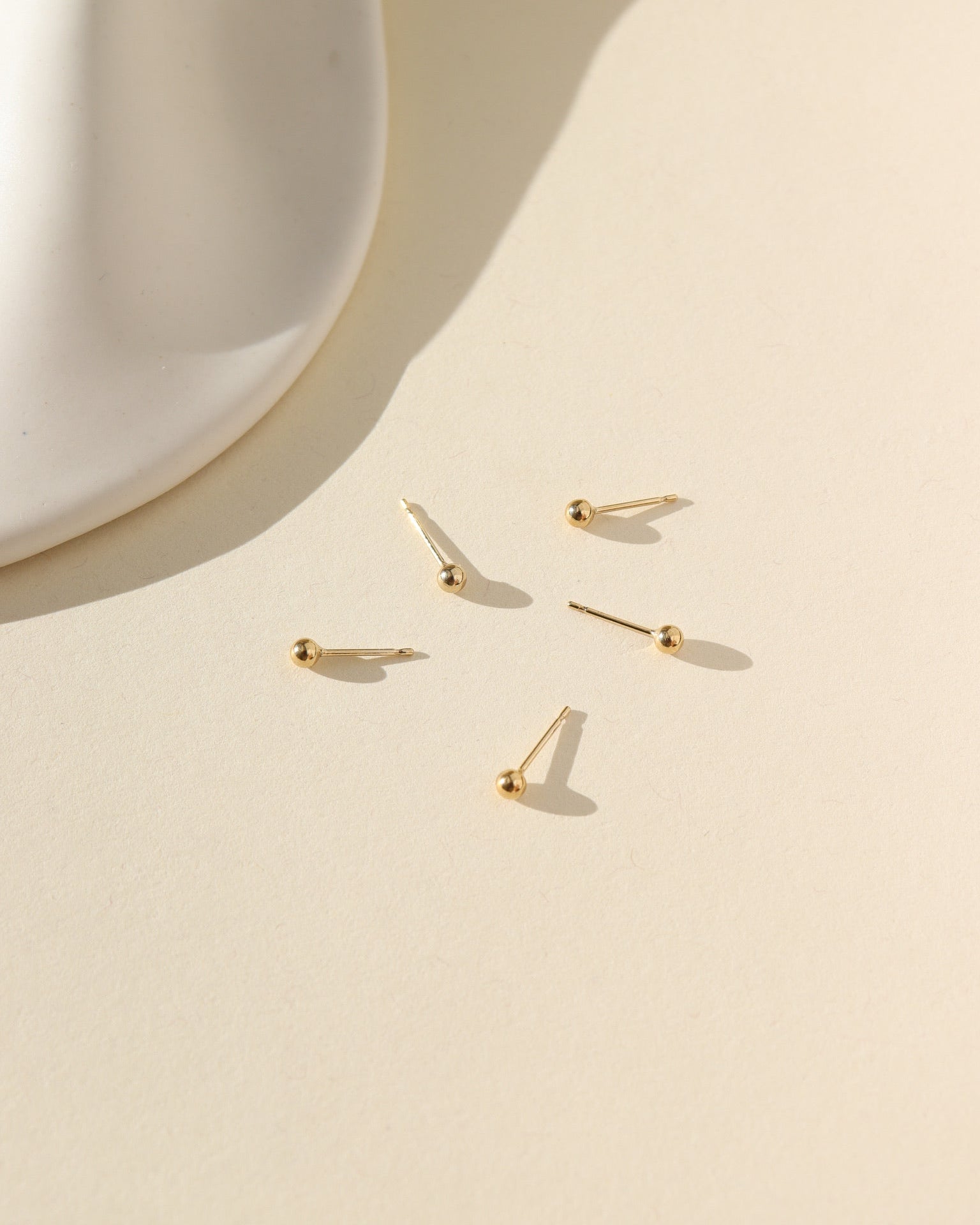 gold fill classic studs laid in the sun