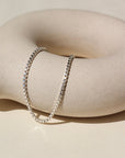 925 sterling silver Delaney anklet laid on a tan pot