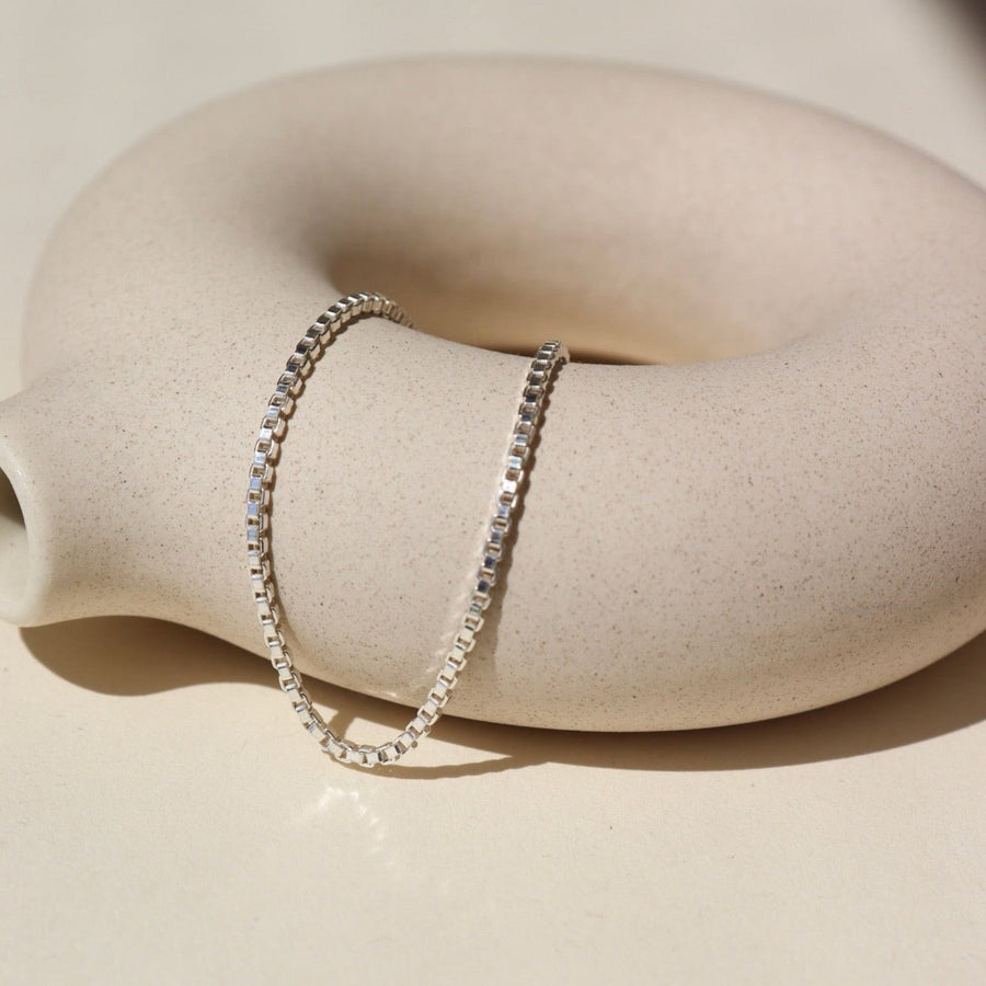 925 sterling silver Delaney anklet laid on a tan pot