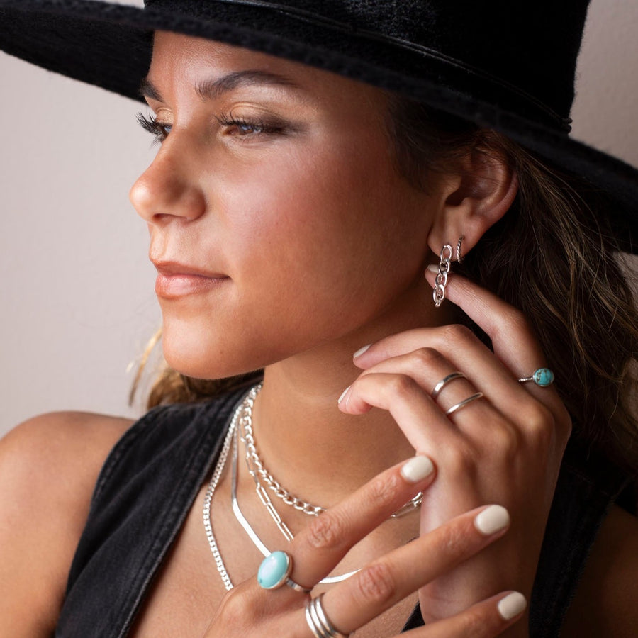 925 sterling silver chain earrings photographed on a brunette model wearing a black cowboy hat