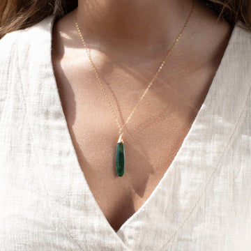 Token Jewelry standard chain necklace with a long green malachite stone, photographed on a model wearing an off white linen vest