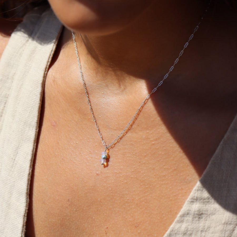 Model wearing 925 sterling silver Gender reveal Necklace. This necklace features a beautiful mini paper clip chain that is met together with either a pink or blue opal gemstones.