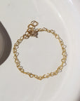 14k gold fill heart link chain in children's sizes, photographed on a ceramic white plate