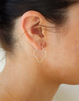14k gold fill 4-leaf clover shaped slide earrings, photographed on a brunette model