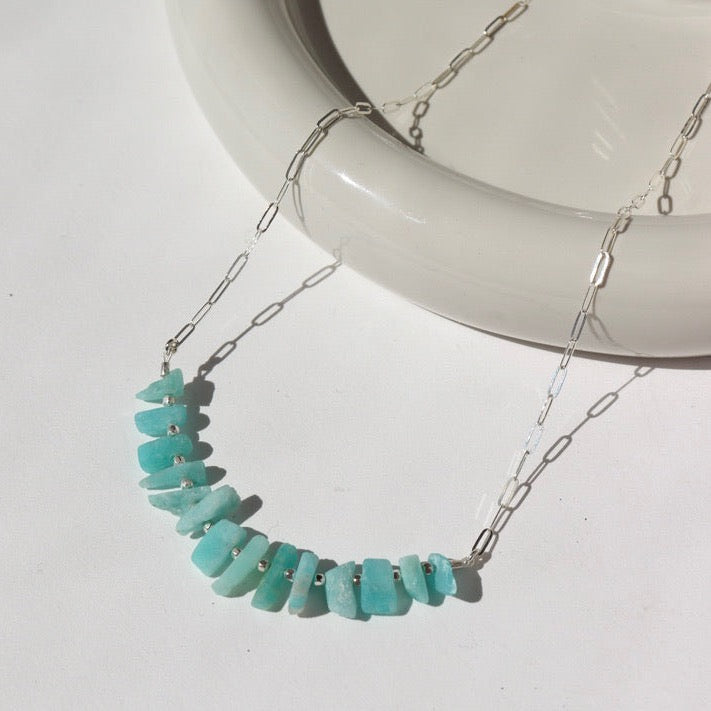 925 Sterling silver Apatite necklace laid on a white plate in the sunlight.