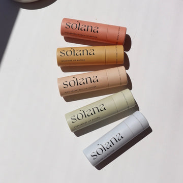Solana Lip Balm Laid on a white paper in the sunlight.