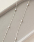 dainty pearls on a sterling silver chain photographed on a ceramic dish