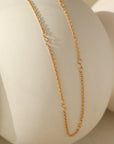 14k gold fill Avery Chain laid across a white pot. 