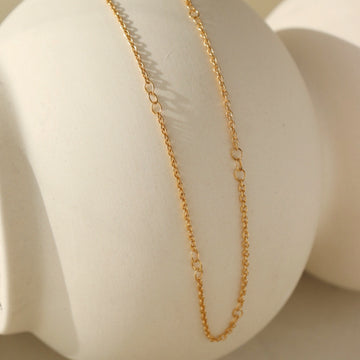 14k gold fill Avery Chain laid across a white pot. 